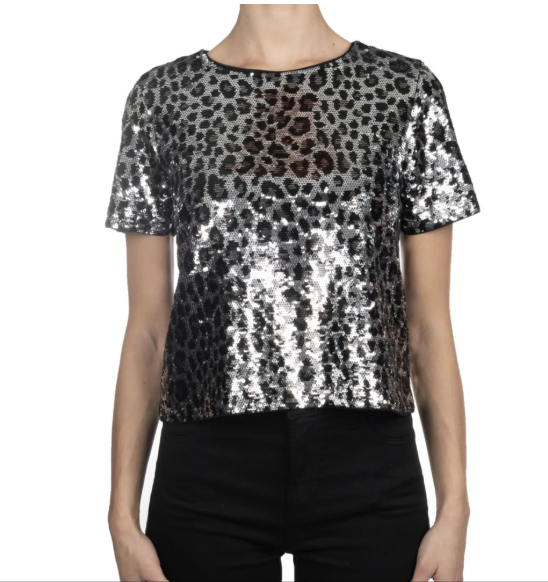 Front view of a model wearing the Michael Kors silver and black sequined short-sleeved crop top with black trousers.