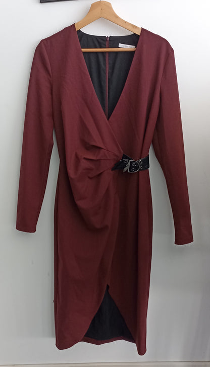 Front of the burgundy Patrizia Pepe dress on a hanger, showing the draped V-neck, black waist buckle and overlapping hem.